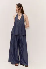 Pantalón de pierna ancha color azul, con pliegues frontales y caída suave.