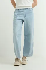 Pantalón jean de corte balloon, color celeste claro, tiro medio y diseño amplio en las piernas con costuras en las rodillas.