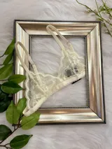 Bralette de encaje estilo triángulo color champagne, con breteles regulables y cierre de gancho en la espalda.