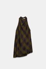 Top de cuello halter con espalda descubierta, confeccionado en tejido de viscosa con estampado de cuadros en tonos verde oliva y negro. Presenta un diseño asimétrico en el bajo y cierre con botones en la parte posterior del cuello.