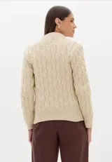 Cardigan de punto trenzado color beige, con cuello redondo, cierre frontal con botones dorados y mangas largas con puños acanalados.