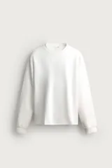 Camiseta relaxed fit de manga larga color blanco, confeccionada en tejido de modal y algodón fluido, con cuello redondo y puños de rib.