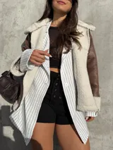 Campera tipo gamulán color marrón con interior y solapas de corderito sintético en color crema. Presenta cierre frontal, bolsillos laterales y diseño de corte holgado.