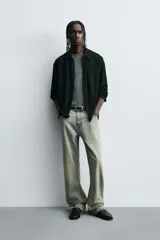 Camisa de hombre de corte relaxed fit, color negro, con textura de cuadros en relieve. Presenta cuello solapa, manga larga con puño abotonado y cierre frontal de botonadura.