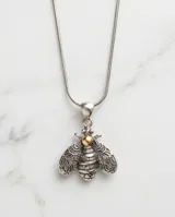 Dije con forma de abeja elaborado en plata 925 con detalles en lámina de oro 18k. Presenta un diseño detallado en las alas y cuerpo con acabado envejecido.