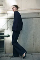 Blusa de crepé de gasa color azul marino, con cuello mao y abertura frontal con tiras finas. Presenta un diseño holgado con volados verticales en el frente, mangas largas tipo globo con corte raglán y puños elásticos con volados.