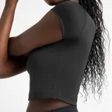 Remera deportiva corta New Balance Harmony Fitted, color negro, de calce ajustado y mangas cortas. Presenta logo de la marca en el pecho.