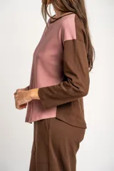Sweater de algodón con textura tipo waffle, diseño bicolor con cuerpo en color rosado y mangas largas en color marrón. Presenta cuello redondo y un calce holgado.