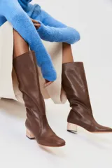 Botas de caña alta de cuero negro, con punta redonda y taco cuadrado de madera.