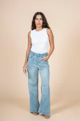 Jean de tiro alto con corte recto y silueta amplia, confeccionado en denim de lavado claro. Presenta cierre frontal con botón y bolsillos laterales y traseros.