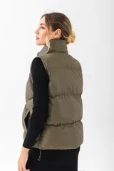 Chaleco puffer negro con cuello alto, cierre frontal y bolsillos laterales.