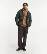 Campera puffer ultraligera de color beige, con diseño acolchado de gajos horizontales, capucha incorporada, cierre frontal y bolsillos laterales con cremallera. Confeccionada en poliamida con relleno de poliéster.