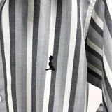 Camisa de manga larga a rayas verticales en tonos grises, con cuello italiano y logo bordado en el pecho.