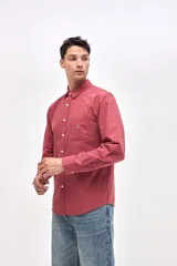 Camisa de corte regular fit confeccionada en algodón, con cuello clásico, cierre frontal de botones y bolsillo en el pecho con detalle bordado.