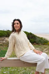 Sweater color crema de lana merino y alpaca, tejido a mano con cuello redondo y mangas largas con calados.