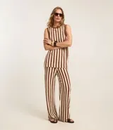 Pantalón de punto color crema con rayas verticales marrones, de corte recto y cintura alta con elástico.