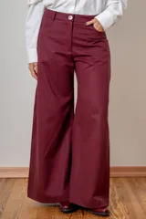 Pantalon de corte wide leg en color bordó, con cintura alta, cierre frontal con botón y bolsillos laterales.