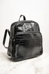 Mochila negra de cuero vegano con textura croco, tamaño mediano, con doble compartimento con cierre y correas ajustables.