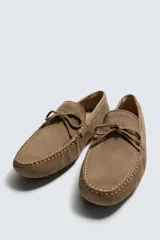 Mocasín casual fabricado en piel con acabado serraje, con detalle de lazo en el empeine y horma redonda.