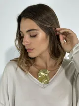 Gargantilla dorada con dije circular irregular.