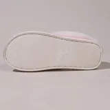 Pantufla cerrada de gamuza gris con interior y borde de peluche blanco, suela de goma antideslizante.