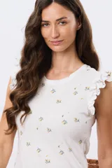 Remera blanca de algodón con estampado de ramas y pequeños frutos, escote redondo y mangas cortas con volados.