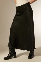 Falda midi evasé de poliéster color negro con textura sutil.