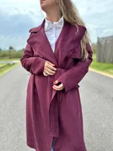 Tapado largo color borgoña, con cuello solapa, mangas largas y lazo para ajustar en la cintura.