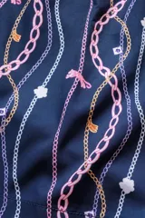 Short de baño azul marino con estampado de cadenas doradas, charms y libélulas en rosa.