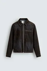 Cazadora de hombre de corte relajado, confeccionada en tejido con algodón de acabado flocado efecto terciopelo lavado, color marrón oscuro con efecto desgastado. Presenta cuello solapa, cierre frontal de cremallera, bolsillo con cremallera en el pecho y bolsillos laterales en la costura de la cadera.