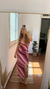 Conjunto de dos piezas compuesto por un top strapless y una falda midi con tajo lateral, ambos confeccionados en tejido elástico con estampado de ondas en tonos rosados, fucsias y violetas.