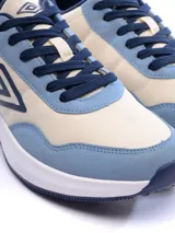 Championes Umbro modelo Volcan, con diseño urbano en combinación de colores beige y azul. Presentan el logo de la marca en el lateral, suela blanca de plataforma y cierre con cordones.