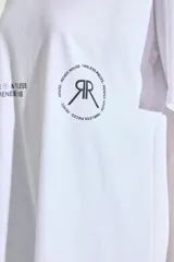 Remerón de corte oversized confeccionado en algodón, con cuello redondo y mangas cortas. Presenta estampados gráficos en color negro en la parte frontal.