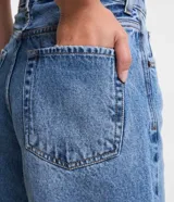 Short de jean celeste con tiro alto, corte mom, bolsillos delanteros y traseros, y lavado con efecto desteñido.