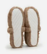Pantufla cerrada de estilo zapatilla, confeccionada en poliéster con revestimiento de textura felpuda en color tostado.