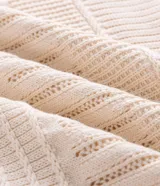 Polo de manga corta confeccionada en tejido de punto de algodón con textura de cables y relevos. Presenta cuello polo con abertura en V y un diseño de calce cómodo.