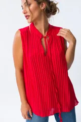 Blusa roja sin mangas con cuello mao y lazo al cuello.