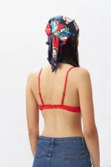 Top de bikini blanco con escote halter, abertura circular en el centro y lazos ajustables.