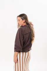 Camisa de broderie color marrón chocolate, con cuello alto, detalles de volados, mangas largas abullonadas y cierre frontal de botones.