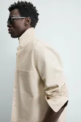 Sobrecamisa de algodón color beige claro, de corte relajado, con cuello solapa, manga larga y dos bolsillos de plastrón en el pecho.