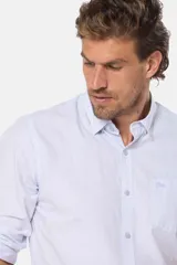 Camisa celeste a rayas verticales, de manga larga con opción de enrollar, corte slim fit, con bolsillo en el pecho y confeccionada en algodón.