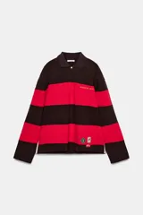 Polo de manga larga con cuello solapa y cierre frontal de botones. Diseño a rayas horizontales anchas en color negro y rojo. Presenta texto bordado en el pecho y parches decorativos en la parte inferior delantera.