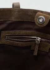 Bolso tipo shopper de cuero de serraje en color marrón oscuro. Cuenta con dos asas de hombro, cierre de botón magnético y un bolsillo interior con cremallera.