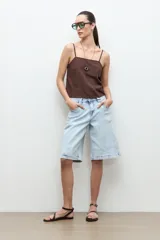 Bermuda de jean de tiro medio, color celeste claro, con diseño amplio estilo bermuda y bolsillos laterales y traseros.