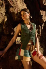 Chaleco corto tejido a crochet color verde oliva, con escote en V y cierre frontal con lazos.