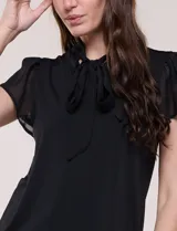 Blusa blanca elegante con cuello con lazo integrado para anudar al frente, escote en V sutil y mangas cortas estilo mariposa de gasa translúcida.