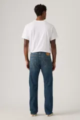 Jeans de mezclilla azul con lavado medio, corte de pierna recta y tiro medio. Presenta cinco bolsillos, cierre frontal con botones y trabillas para cinturón.