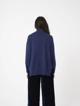 Sweater de cuello alto con mangas amplias y puños ajustados, confeccionado en tejido de punto con acabado liso.