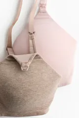 Pack de dos soutienes maternales de algodón suave, uno en color rosado y otro en tono beige. Cuenta con tirantes ajustables y copas preformadas sin aros, con apertura superior diseñada para la lactancia. Cierre posterior con corchetes.
