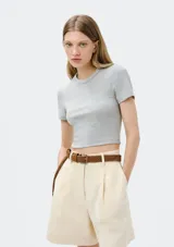 Blusa corta de tejido de punto acanalado, con cuello redondo y mangas cortas, de ajuste entallado al cuerpo.